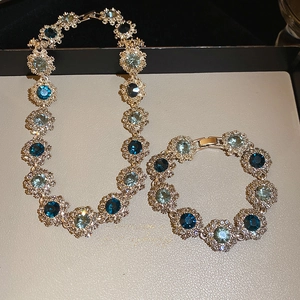 Detail of luxury vintage flower necklace and bracelet set with blue crystals