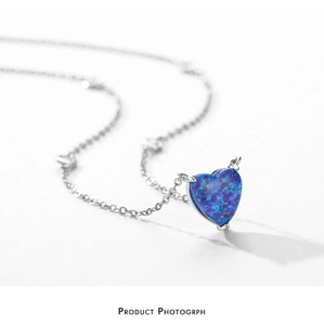 Detail of S925 silver necklace with heart-shaped blue opal and devil horn pendant