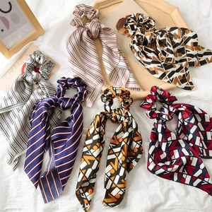 Detail of six satin scrunchies with long ribbons in colorful geometric and striped patterns