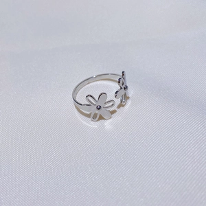 Détail d'une bague ouverte fleur en argent avec un anneau métallique poli ajustable