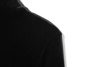 Detailed view of black velvet fabric texture and shoulder stitching on a mini dress