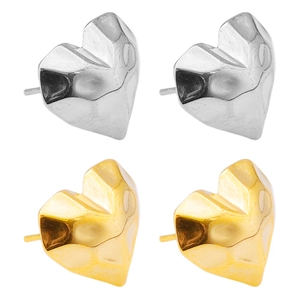 Macro detail of heart-shaped studs in gold and silver with hammered metal texture