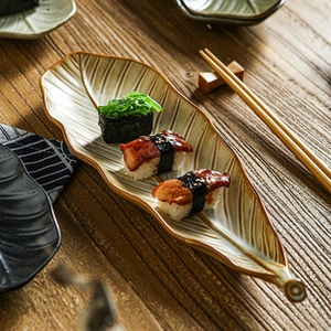 Macro view of leaf-shaped ceramic sushi tray with natural glaze and vein details