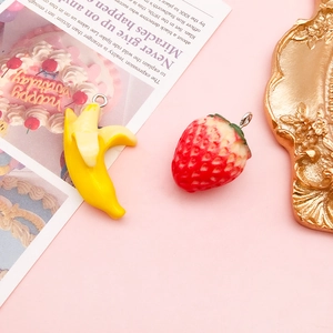 Close-up of acrylic strawberry and banana pendants for DIY jewelry and crafts