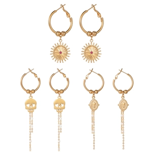 Golden earring set featuring sun studs, skull tassels, and cross heraldry designs