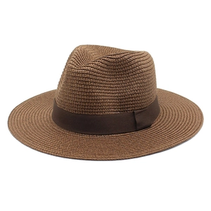 Close-up of fine woven texture and dark brown ribbon on a summer straw panama hat