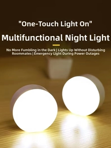 Macro shot of two round warm white LED night lights with touch sensor on a wooden table