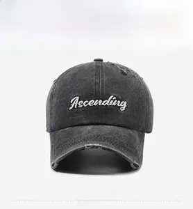 Close-up of white Ascending embroidery and distressed details on a washed charcoal cap