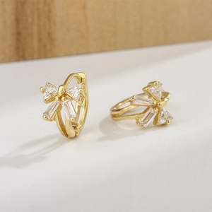 Elegant gold bow earrings with sparkling baguette zircons and easy-to-use hoop closure
