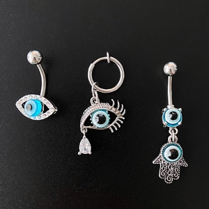Détails de piercings de nombril argentés avec œil bleu, main de Hamsa et pendentifs zircon