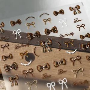 Macro shot of 5D bow and butterfly nail art stickers with vintage plaid textures