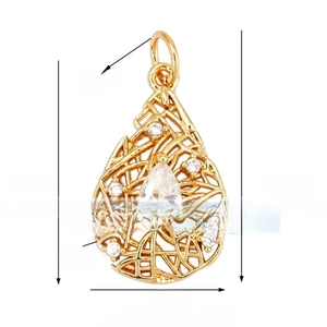 Macro shot of 18K gold lace pendant with pear-shaped stone and filigree metal details