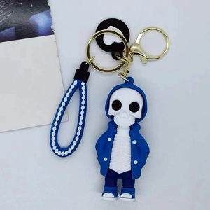 Cartoon skeleton keychain with blue hoodie and woven strap on a clean white background