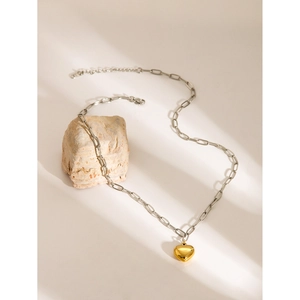 Two-tone 18k gold plated heart pendant necklace with silver O-chain on stone pedestal
