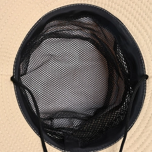 Detail of khaki hiking hat interior featuring black breathable mesh and adjustable wind cord