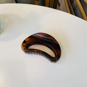 Macro detail of medium tortoiseshell hair claw clip with a sleek semi-circle design