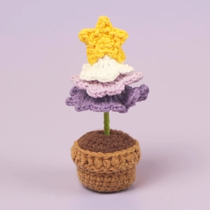 Détail macro d'un mini sapin de Noël fait main au crochet avec étoile et fleurs