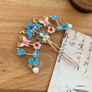 Détail du pic à cheveux en U avec papillon émaillé bleu et pendentif en perle