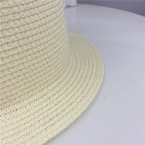 Detailed close-up of woven straw hat texture showing fine cream craftsmanship