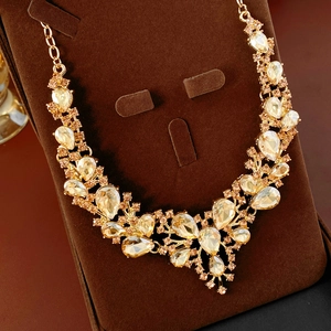 Macro shot of luxury V-shaped necklace with champagne water-drop crystals and gold metal
