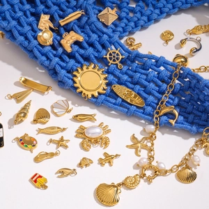 Detailed close-up of golden ocean-themed charms and a pearl bracelet on a blue woven bag