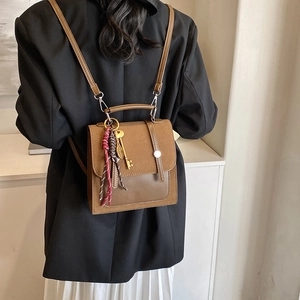 Mochila vintage marrón para mujer con amuleto de llave dorada y detalles de gamuza