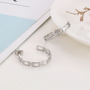 Detailed shot of hollow chain design silver C-shape earrings on minimalist background