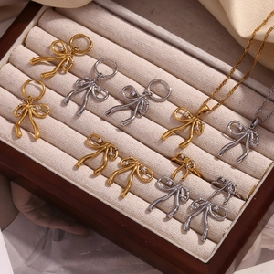 Detail view of 18K gold and silver bow jewelry set with rhinestones in a beige velvet box