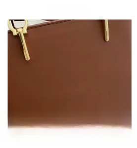 Close-up of caramel brown leather handbag with premium stitching and gold metal hardware