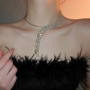 Detail of luxury irregular rhinestone tassel necklace on model with black feathers