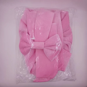 Close-up of a pink velvet giant bow decoration packaged in a clear plastic bag for events