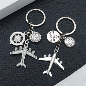 Detail of silver globe keychain with airplane and 'no matter where' engraved charm