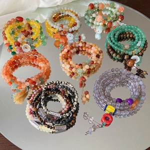 Nahaufnahme von Perlenarmbändern mit Naturachat, Chalcedon und Blumenanhängern
