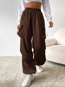 Detail of brown high-waist cargo pants featuring side pockets and elastic drawstring waist