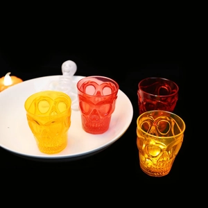 Glow-in-the-dark skull shot glasses in red and yellow for Halloween party decor