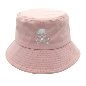 Gros plan sur un bob en coton rose avec broderie tête de mort et os blanche
