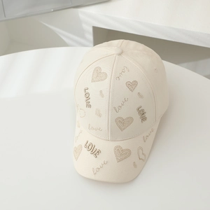Gros plan détaillé de la broderie cœur et du texte LOVE sur la casquette enfant