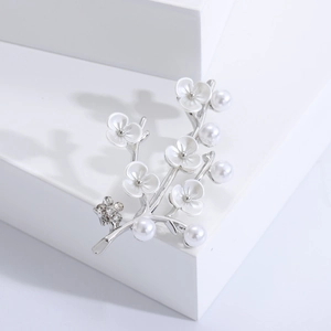 Detail of silver plum blossom brooch with white pearl and rhinestone on cubes