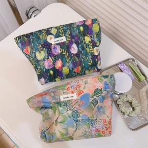 Detail of floral cotton makeup bags with zippers and simple wish labels on white surface