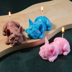 Three colorful sleeping bulldog candles with realistic texture on a wooden tray