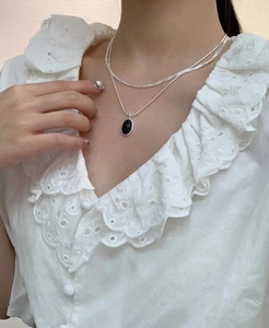 Close-up of layered S925 silver snake chain with a vintage black onyx oval pendant