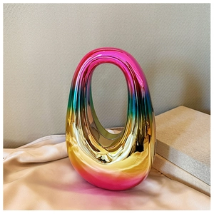 Close-up of iridescent acrylic oval evening bag with glossy metallic finish and handle