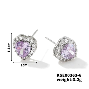 Macro view of heart-shaped silver earrings with purple center stone and white diamonds