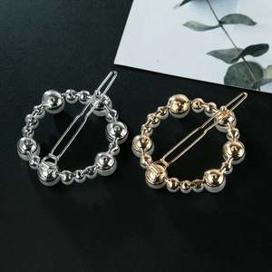 Minimalist gold and silver irregular round hair clips with faux pearls set on black background