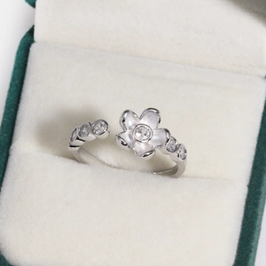 Detailed view of a silver floral ring with zircon stones in a velvet jewelry box