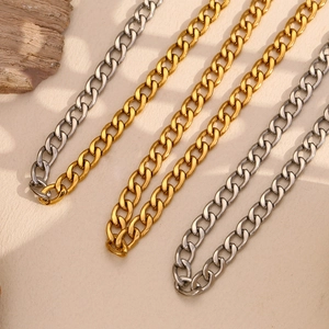 Parallel gold and silver Cuban link chains showing polished texture on a neutral surface