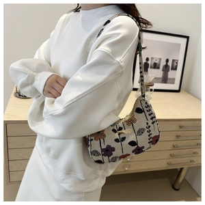 Detailed texture of corduroy underarm bag with strawberry floral embroidery on canvas