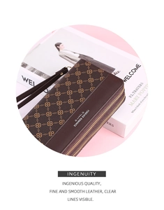 Detailed macro view of brown embossed long wallet with double zipper and wrist strap