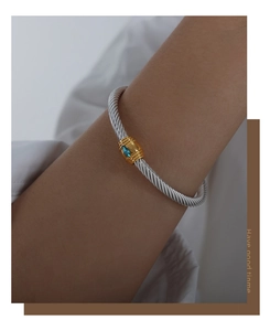 Detail of cable twisted cuff bracelet with golden inlay and blue marquise stone