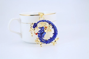 Close-up of blue enamel and gold-plated dragon pendant keychain for car keys and bags